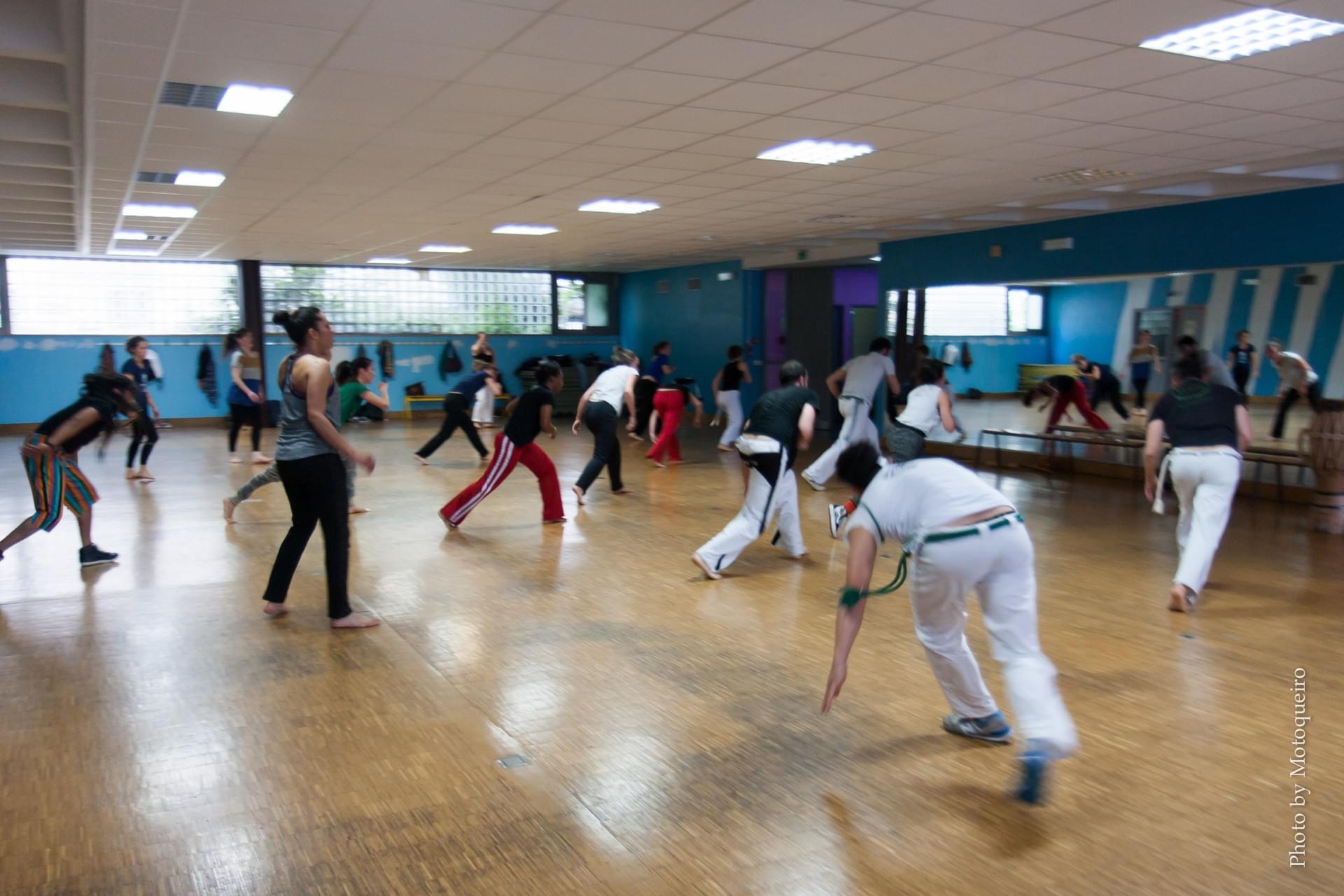 Cours collectif de capoeira, adultes en mouvement