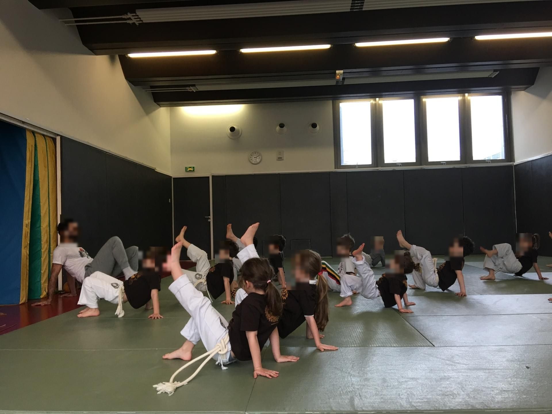 Cours enfants, exercice de pont (visages floutés)